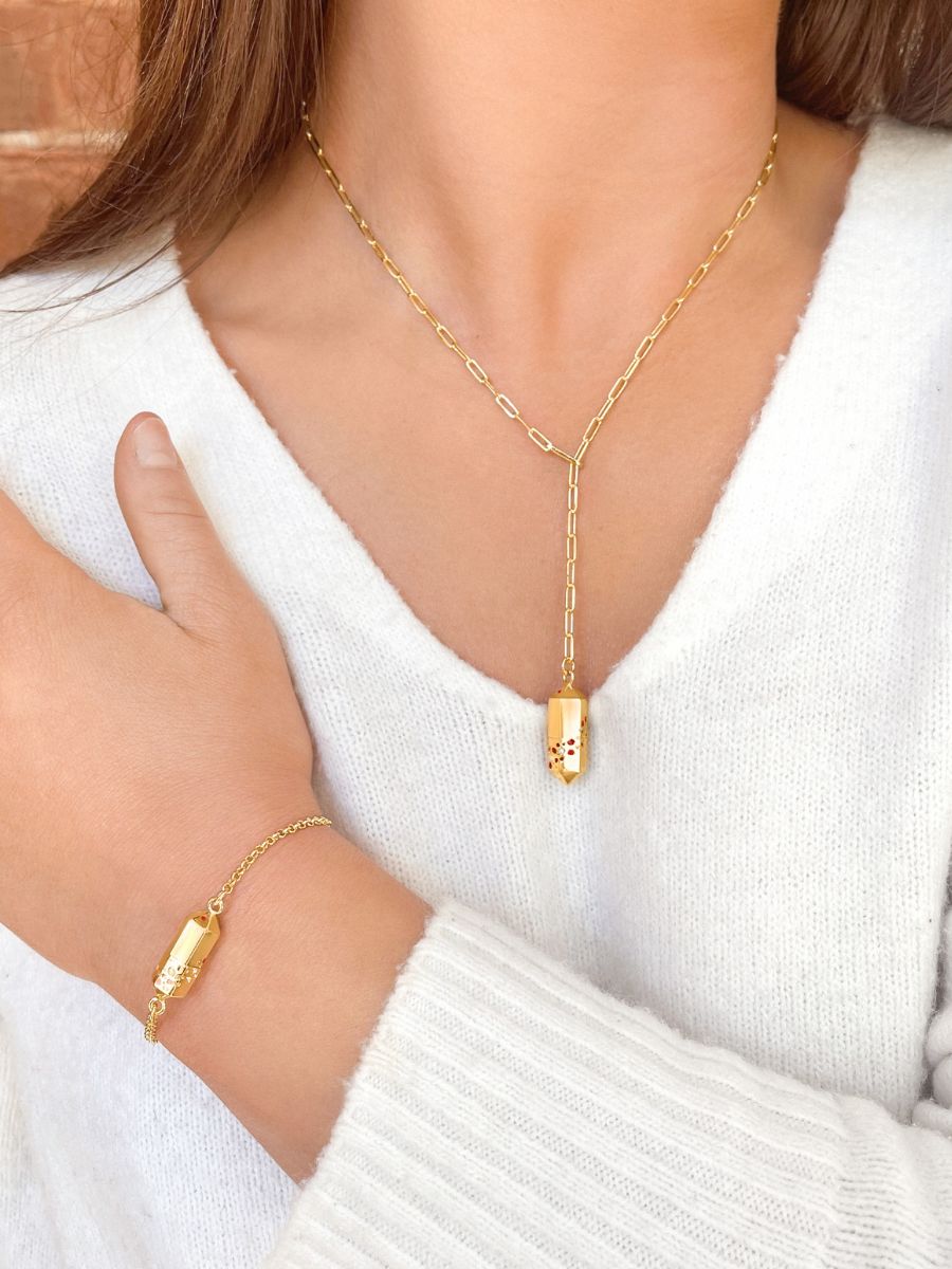 A model wearing a matching Polygon Lariat Locket and Polygon Bracelet in gold. 