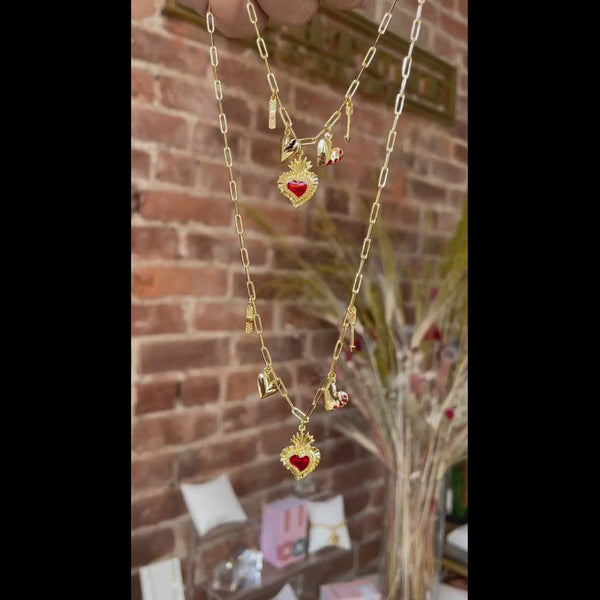 A video of the Heart Phases Charm Necklace. Two necklaces are held, styled as if they were layered together.  The video shows how the charms dangle from the paper clip chain.