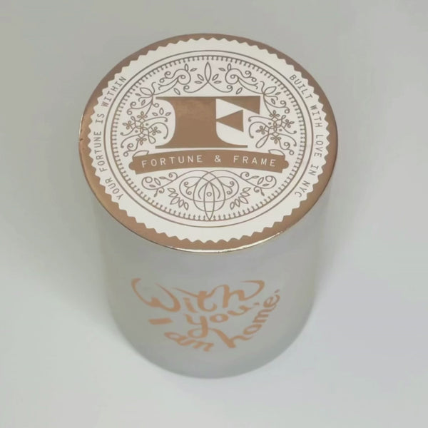  Video of a white candle with the words "With you, I am home." written in rose gold, in front of a white background. Video shows the process of the candle burning to reveal the hidden message inside that reads “There’s no place I’d rather be”.