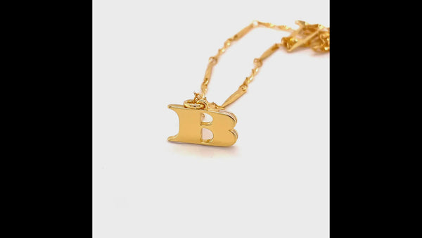 A 360 degree video of the gold B letter necklace. The 360 video focuses on the B pendant and shows the front and the back which has the signature wave design.