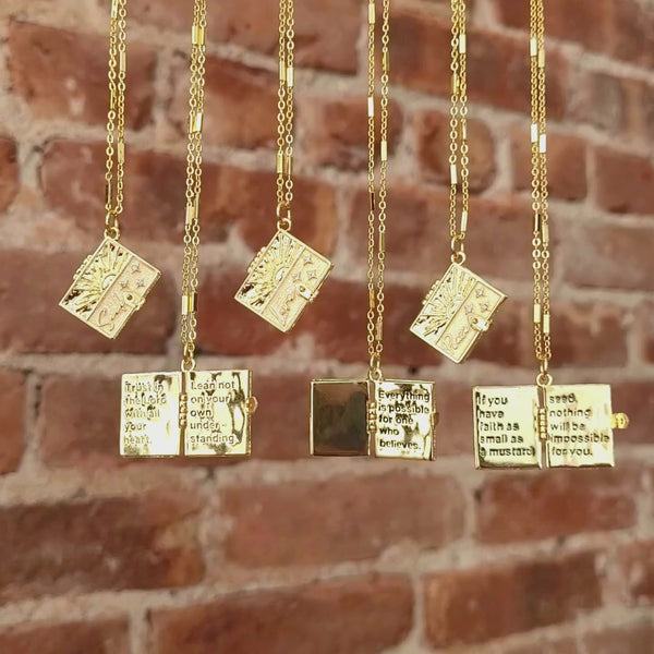 All 6 of our Secret Scripture Lockets hanging, and three of them are opened to show the message inside. 