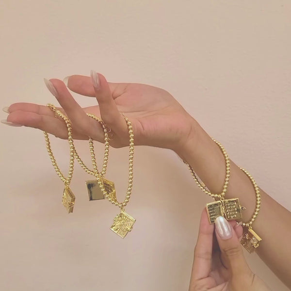  A model hand holding 5 fortune bracelets and opening one with her other hand.